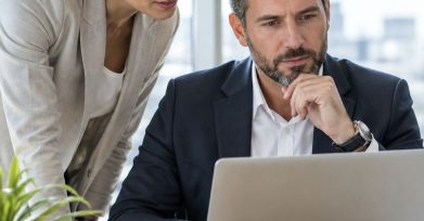 Business leaders reviewing a generative AI project proposal on a laptop